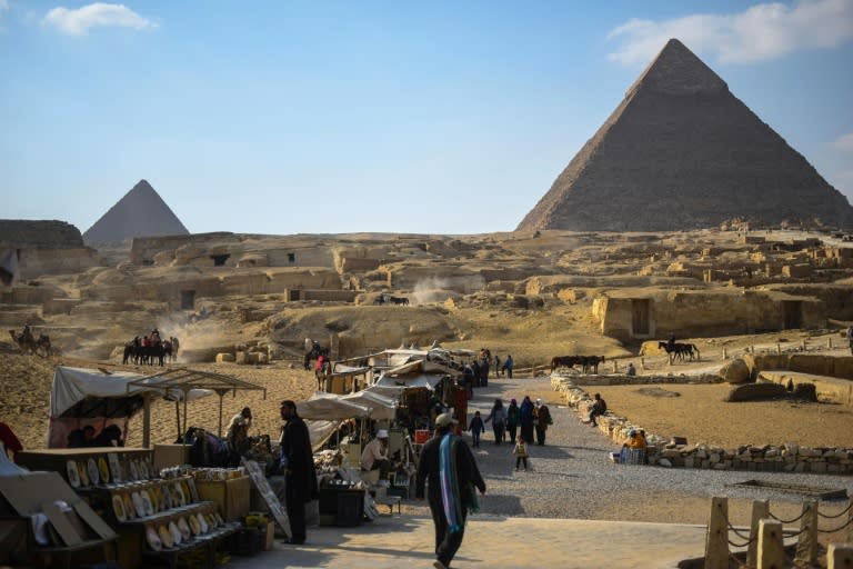 Street vendors wait for customers near the Giza pyramids in the southern Cairo Giza district on January 20, 2016