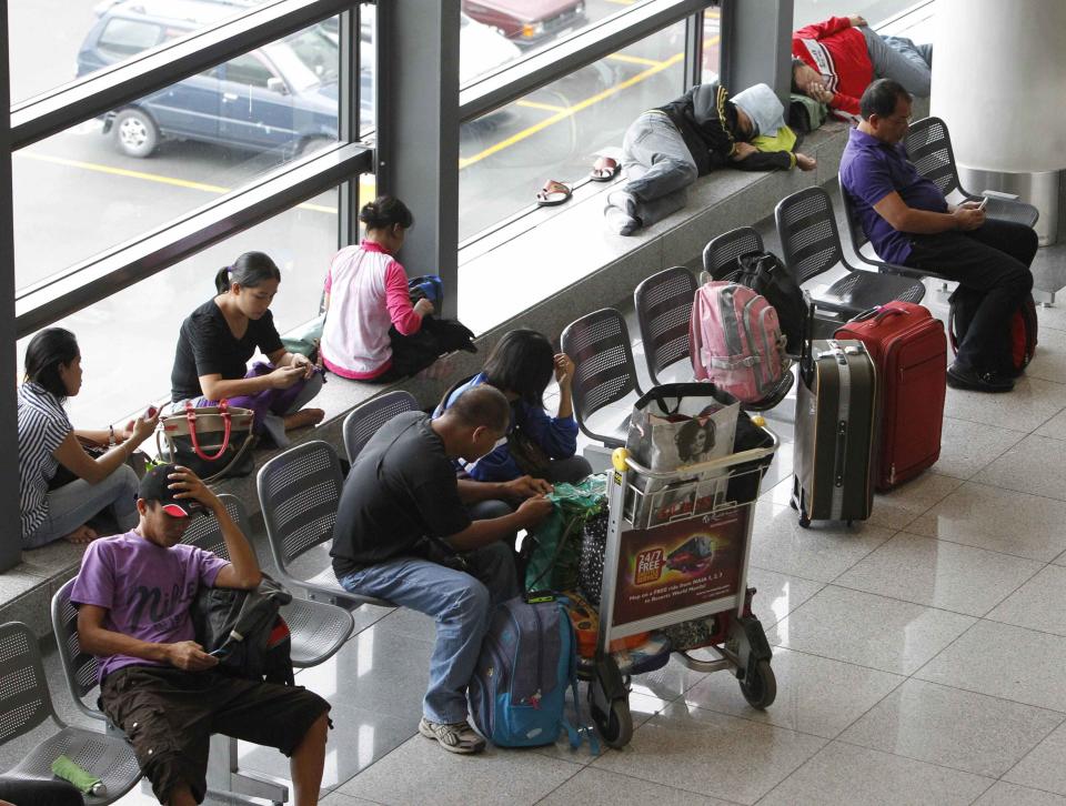 Stranded passengers wait at the lobby of Ninoy Aquino International airport in Pasay city, metro Manila November 8, 2013 after nearly 200 local flights have been suspended due to Typhoon Haiyan that hit central Philippines. Typhoon Haiyan, the strongest storm on earth this year, slammed into the Philippines' central islands on Friday forcing millions of people to move to safer ground and storm shelters, cutting power and phone lines, and grounding air and sea transport. The maximum category-five super typhoon, with destructive winds gusting of up to 275 kph (170 mph), whipped up giant waves as high as 4-5 meters (12-15 feet) that lashed the islands of Leyte and Samar, and was on track to hit holiday destinations REUTERS/Romeo Ranoco (PHILIPPINES - Tags: DISASTER ENVIRONMENT TRANSPORT)