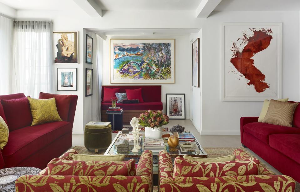 “At the time I bought this apartment, Downton Abbey had just premiered, and I wanted to infuse some Lady Mary red into the space, so these are my Lady Mary sofas, which were custom made.” Red painting (on the right) is by James Nares; large center painting by Malcolm Morley. Chairs and table in the foreground are vintage. Ottoman from One Kings Lane.