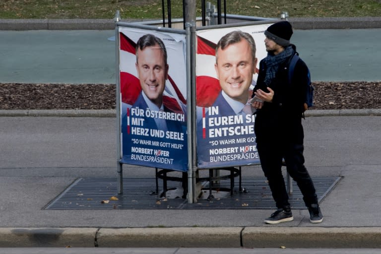 A man stands by a poster of Norbert Hofer, presidential candidate for Austria's right-wing Freedom Party (FPOe), outside the Austrian parliament in November