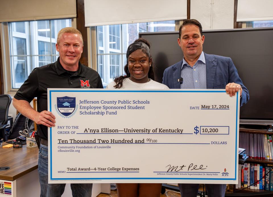 duPont Manual High School senior A'nya Ellison, center, was presented with a scholarship check for $10,200 by JCPS Superintendent Marty Pollio on Friday morning. May 17, 2024.