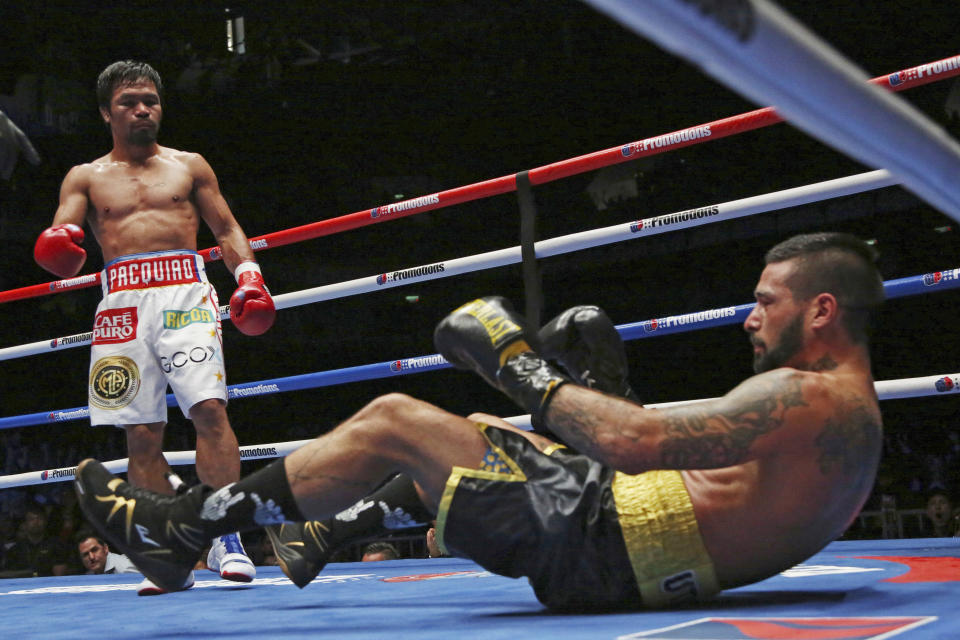 In this Sunday, July 15, 2018, file photo, Lucas Matthysse, left, of Argentina falls after receiving a punch by Manny Pacquiao of the Philippines during their WBA World welterweight title bout in Kuala Lumpur, Malaysia. Filipino boxing legend Pacquiao clinched his 60th victory Sunday with a seventh-round knockout of Matthysse, his first stoppage in nine years, that will help revive his career. (AP Photo/Yam G-Jun, File)