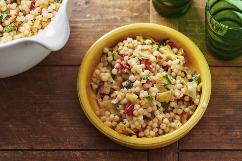 This image shows a vegetarian recipe for Artichoke, Feta and Roasted Pepper Couscous Salad, a nourishing, protein-filled, meat-free meal for lunch. (Cheyenne M. Cohen via AP)