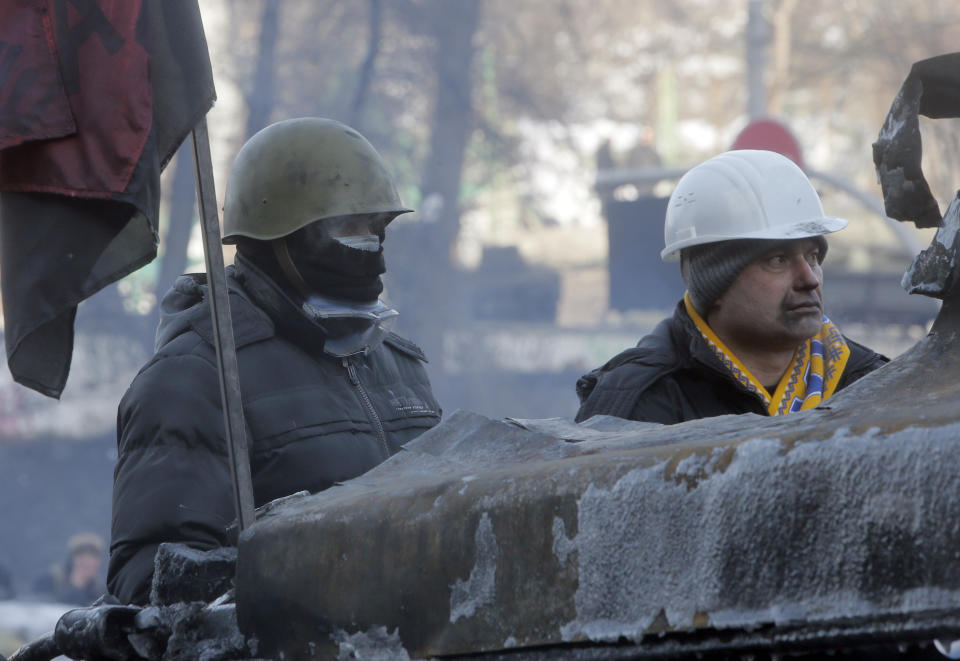 Protesters guard the barricades in front of riot police in Kiev, Ukraine, Monday, Jan. 27, 2014. Ukraine's justice minister is threatening to call for a state of emergency unless protesters leave her ministry building, which they occupied during the night. The seizure of the building early Monday underlined how anti-government demonstrators are increasingly willing to take dramatic action as they push for the president's resignation and other concessions. Protesters now occupy four sizable buildings in downtown Kiev, including the city hall. (AP Photo/Efrem Lukatsky)