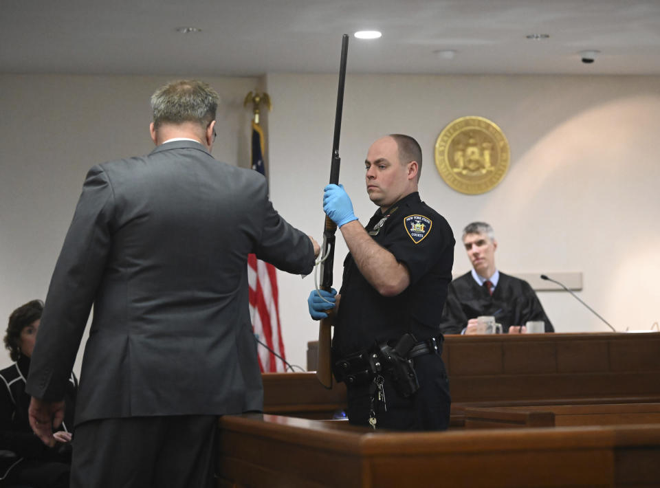 Washington County First Assistant District Attorney Christian P. Morris, left, directs a NYS Court Police officer to hold Kevin Monahan's shotgun during summations in Monahan's murder trial before County Judge Adam Michelini, right, Tuesday, Jan. 23, 2024, at Washington County Courthouse in Fort Edward, N.Y. Monahan, 66, is charged with second-degree murder in the death of Kaylin Gillis, who was riding in a caravan of two cars and a motorcycle that pulled into his dark, winding driveway in rural Hebron, about 40 miles (65 kilometers) north of Albany, near the Vermont border. (Will Waldron/The Albany Times Union via AP, Pool)