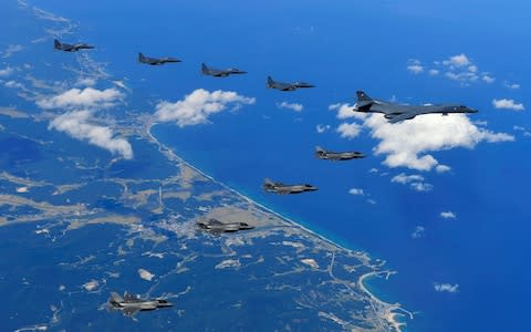 A US Air Force B-1B Lancer bomber (right), US F-35B stealth jet fighters (bottom) and South Korean F-15K fighter jets (top) flying over South Korea  - Credit: AFP