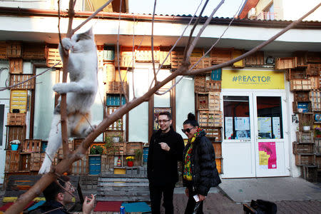 Zita Moldovan (R), Mihai Lukacs (C) and Paul Dunca (L) smoke cigarettes in the grounds of the independent theatre, Reactor during the tour "Roma Theatre is not Nomadic", in Cluj-Napoca, Romania, November 5, 2017. REUTERS/Andreea Campeanu