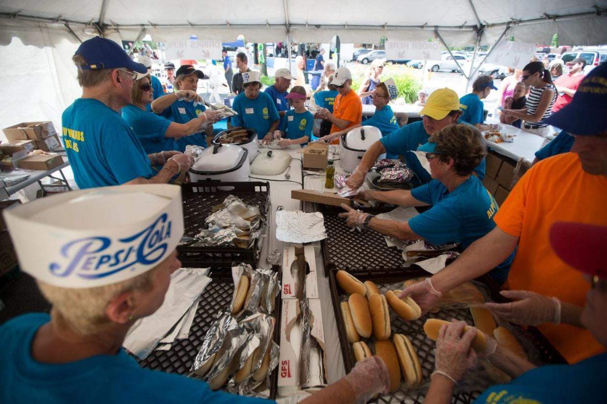 Kiwanis volunteers work to assemble bratwursts Friday, July 17, 2015, during Alpine Kiwanis Annual Brat Days  in Rockford.