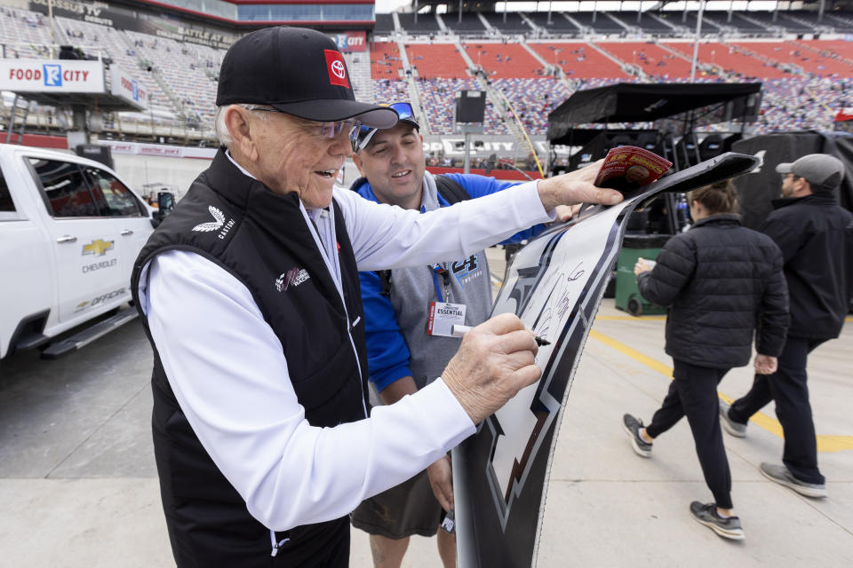 Team owner Joe Gibbs, left, signs a panel for Robert Tate, from Ohio, before a NASCAR Cup Series auto race, Sunday, March 17, 2024, in Bristol, Tenn. (AP Photo/Wade Payne)