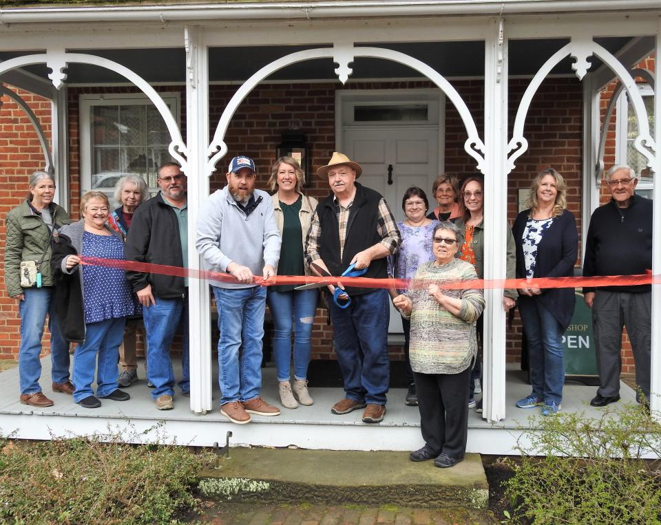 A ribbon cutting was held recently for the new Coshocton Art Guild Gallery and Gift Shop in Roscoe Village. Members of the art guild are present with Mayor Mark Mills, holding ribbon in center, as guild president Jack Hunt cuts the ceremonial ribbon.