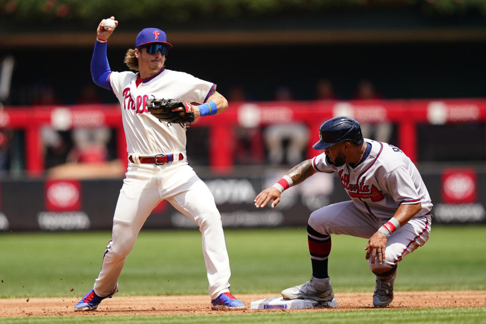 Philadelphia Phillies second baseman Bryson Stott, left, throws to first after forcing out Atlanta Braves' Eddie Rosario at second on a fielder's choice hit into by Marcell Ozuna during the second inning of a baseball game, Wednesday, July 27, 2022, in Philadelphia. Ozuna was safe at first on the play. (AP Photo/Matt Slocum)