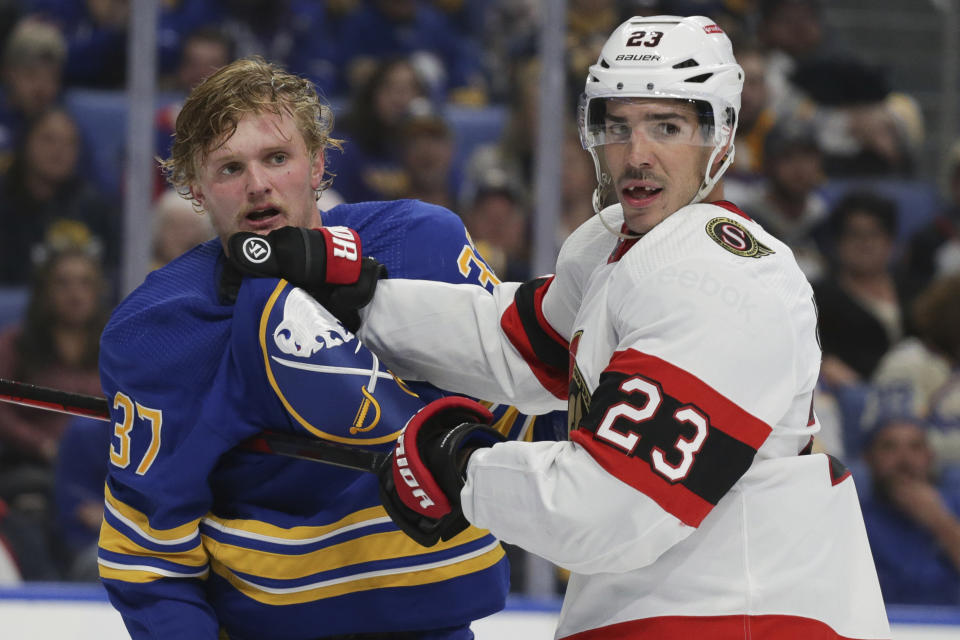 Ottawa Senators defenseman Travis Hamonic (23) holds Buffalo Sabres center Casey Mittelstadt (37) as officials break up a player scrum during the second period of an NHL hockey game Thursday, Oct. 13, 2022, in Buffalo, N.Y. (AP Photo/Joshua Bessex)