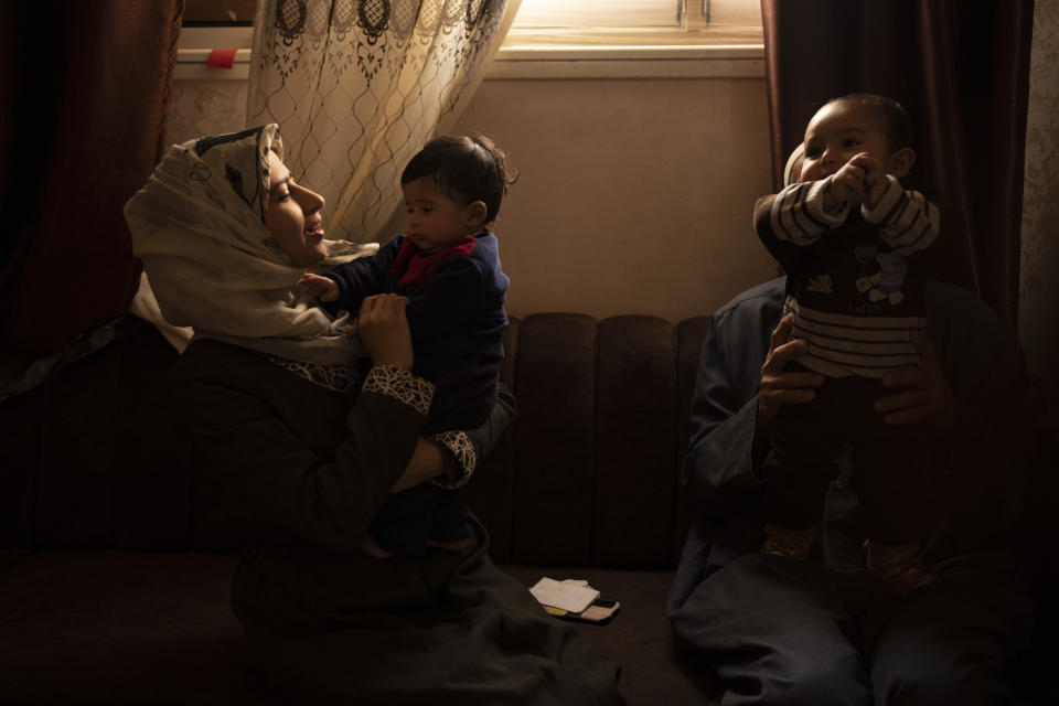 CORRECTS LOCATION - Amal Al-Taweel plays with her baby Ali at her family home in Nuseirat, central Gaza Strip, Friday, April 5, 2024. Ali was born Oct. 7, the day the Israel-Hamas war erupted. Mothers who gave birth in the Gaza Strip that day fret that their 6-month-old babies have known nothing but brutal war, characterized by a lack of baby food, unsanitary shelter conditions and the crashing of airstrikes. (AP Photo/Fatima Shbair)