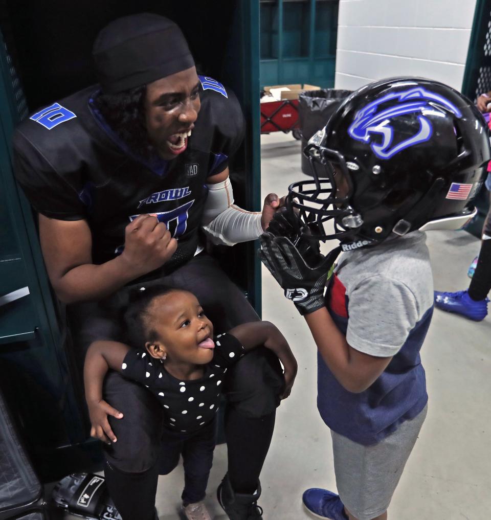 Detroit Prowl Tiera Derrick-Jones has fun with two of her kids Ellie 1 and King Jr. 5 who tries on moms helmet and gloves in the locker room after the win against the Michigan Queens Saturday, April 15, 2023 at Allen Park high school.