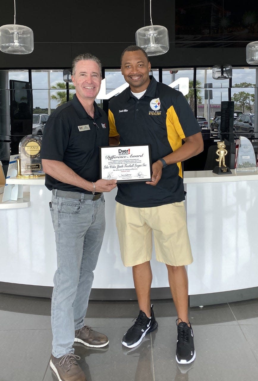 Dyer General Manager David Dlugokecki presents the August Dyer Difference Award to Lake Wales Football League Coach Michael Smith.