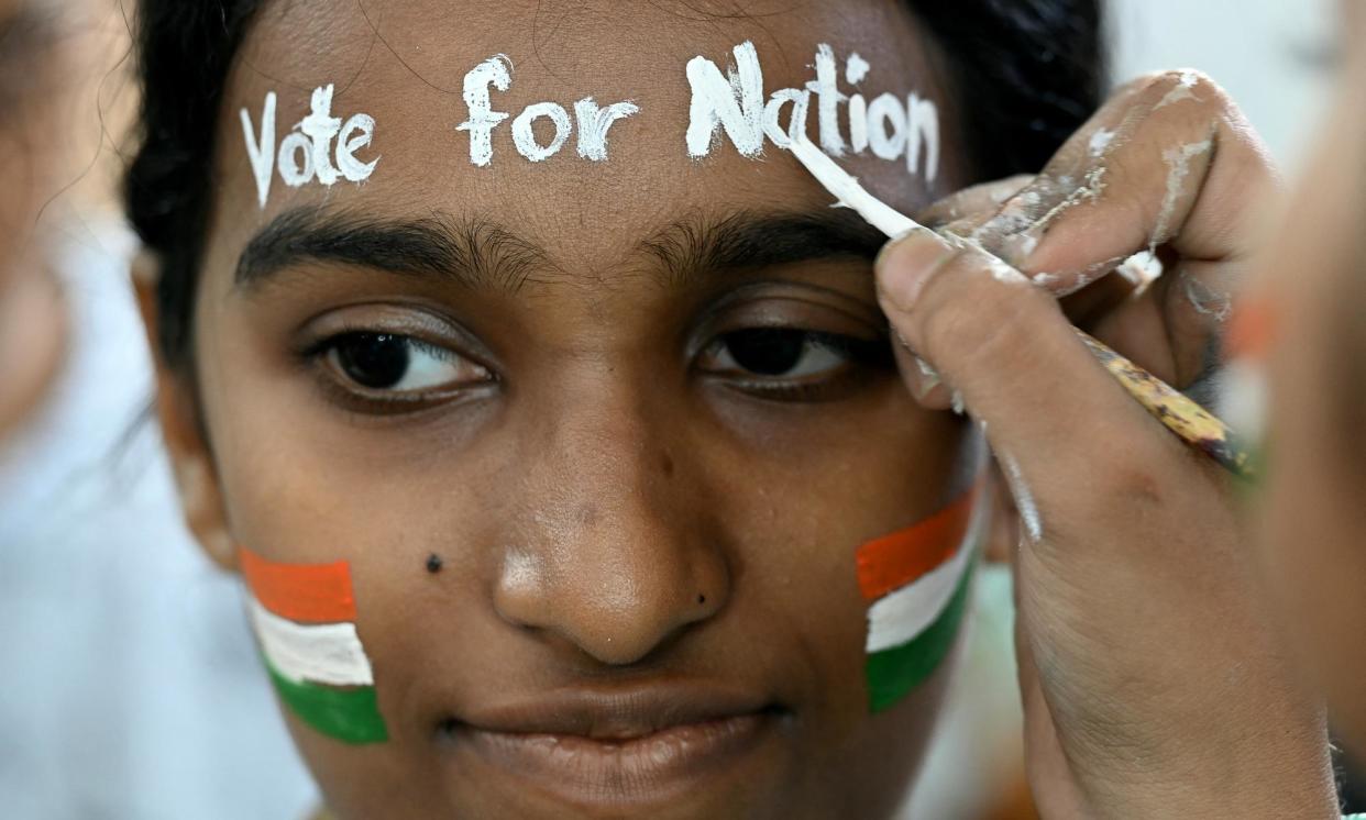 <span>An art school student in Mumbai gets her face painted to encourage people to vote in India's general elections.</span><span>Photograph: Indranil Mukherjee/AFP/Getty Images</span>