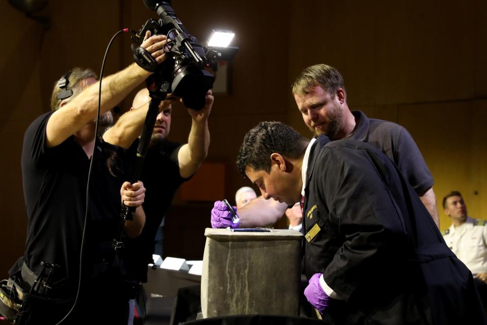 Archaeologist Paul Hudson holds the flashlight as Museum Curator Michael Diaz looks inside a nearly 200-year old time capsule during a livestream event at the U.S. Military Academy at West Point Aug. 28, 2023. The 1-foot-square capsule was found in the base of a monument to Polish Gen. Thaddeus Kosciuszko, who helped the American colonies win their independence from the British.