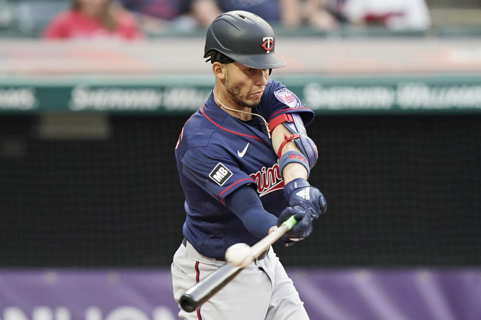 Minnesota Twins' Andrelton Simmons hits an RBI-single in the fourth inning of a baseball game against the Cleveland Indians, Friday, May 21, 2021, in Cleveland. (AP Photo/Tony Dejak)