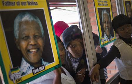 Women look into a memorial service for late former South African President Nelson Mandela organized by the African National Congress (ANC) in Mthatha, South Africa, December 12, 2013. REUTERS/Adrees Latif