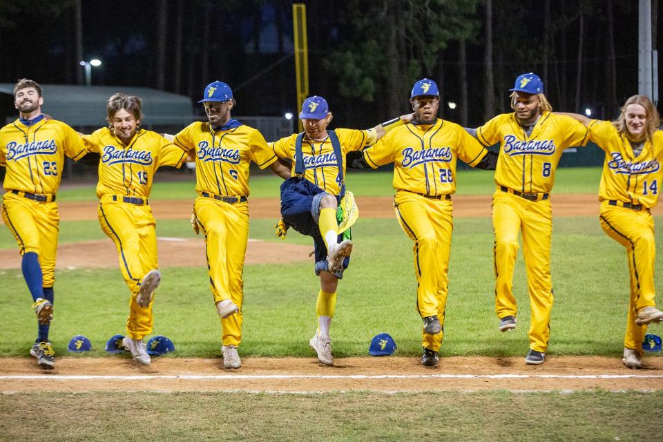 Pitcher/infielder Mat Wolf (4, in blue suspenders and baggy pants), dances in a kick line with teammates on the Savannah Bananas Premier Team before a game against the Party Animals on Saturday, March 12, 2022 at Grayson Stadium. Also pictured, from left, right-handed pitcher Collin Ledbetter (23), outfielder/LHP William Kwasigroh (14), infielder Stephen Felton (5), right-handed pitchers Alex Pierce (26) and Aderlyn Silverio (8) and RHP/utility Dakota "Stilts" Albritton (14).