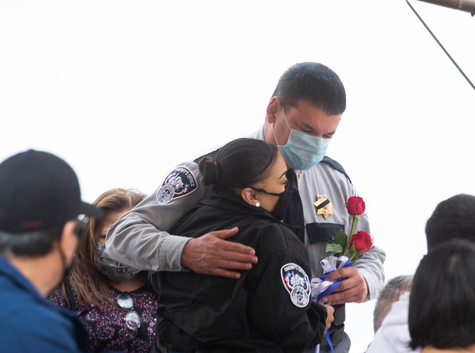 El Paso County Sheriff Richard Wiles gives a flower and hug to Ashley Herrera, the wife of fallen officer Peter John Herrera who was killed in the line of duty March 22, 2019, at the annual memorial ceremony for its fallen deputies on May 12, 2021, at the El Paso Sheriff Department building.