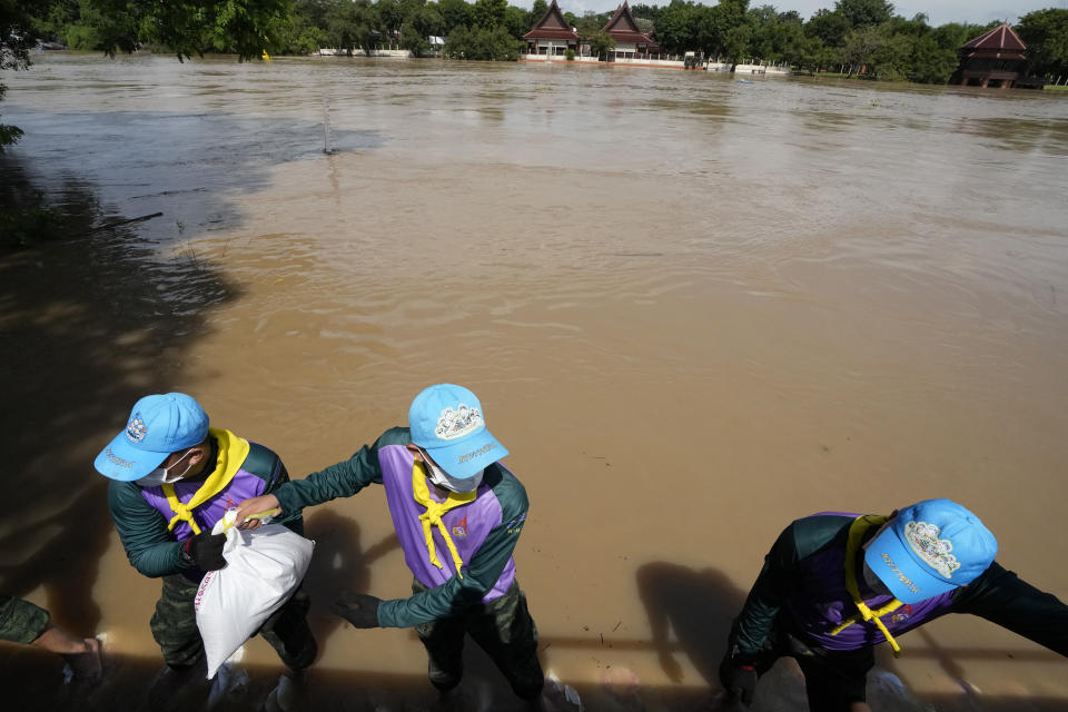 Soldiers stack sandbags to protect Wat Chaiwatthanaram from possible rising flood waters in Ayutthaya province, north of Bangkok, Thailand, Monday, Sept. 27, 2021. Seasonal monsoon rains may worsen flooding that has already badly affected about a third of Thailand, officials said Monday as flood gates and pumping stations were being used to mitigate the potential damage. (AP Photo/Sakchai Lalit)