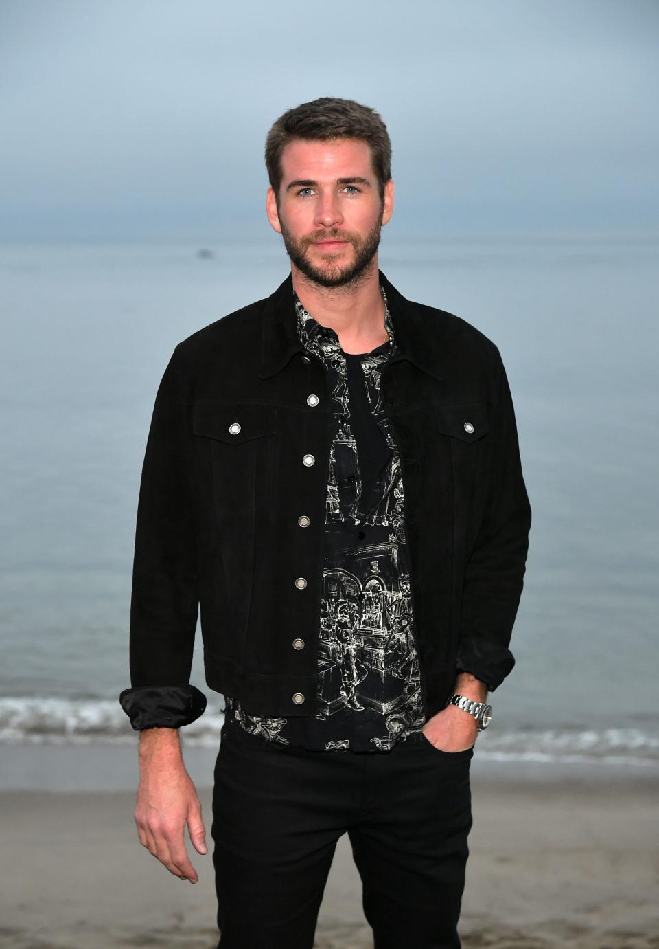 Liam Hemsworth dazzles in a casual black jacket and denim pant to match