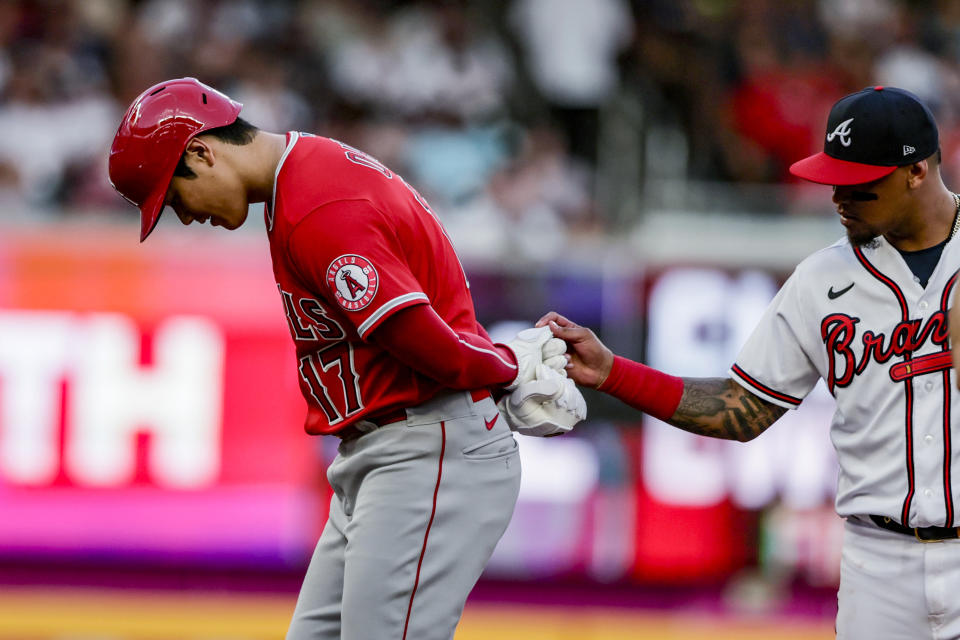 Atlanta Braves second baseman Orlando Arcia, right, checks the glove of Los Angeles Angels' Shohei Ohtani at second base during the third inning of a baseball game Saturday, July 23, 2022, in Atlanta. (AP Photo/Butch Dill)