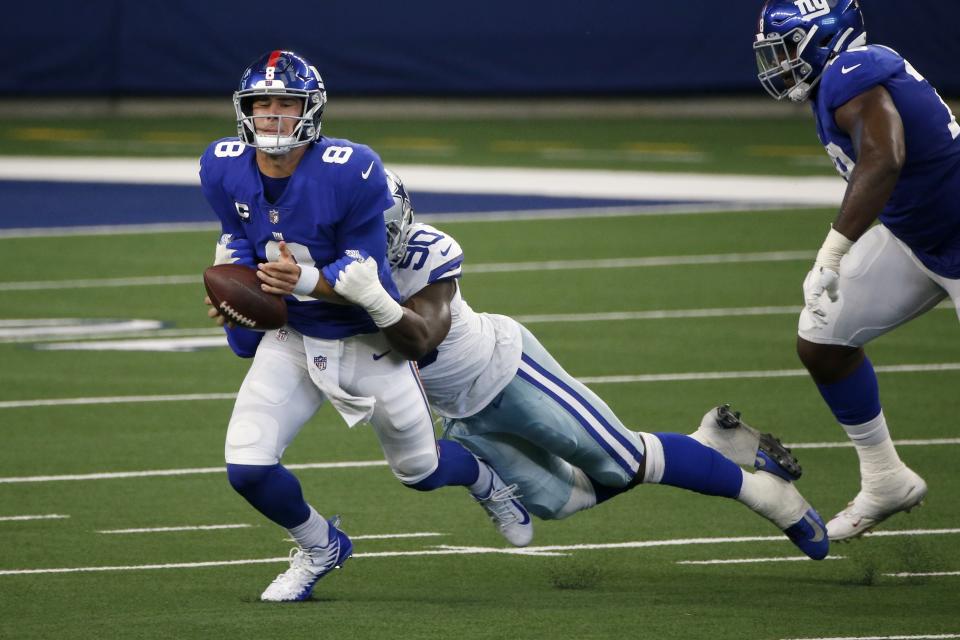 Dallas Cowboys defensive end DeMarcus Lawrence (90) sacks and strips the ball away from New York Giants quarterback Daniel Jones (8) in the first half of an NFL football game in Arlington, Texas, Sunday, Oct. 11, 2020. The Cowboys' Anthony Brown (30) recovered the ball and returned it for a touchdown. (AP Photo/Michael Ainsworth)