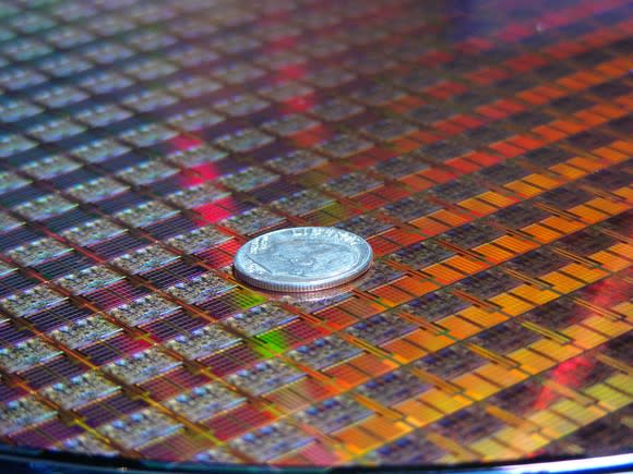 A wafer of Intel processors with a coin on it.