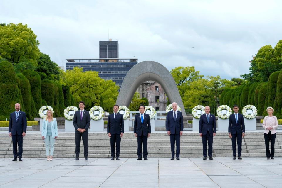 日本首相岸田文雄（中）與美國總統拜登（左）、法國總統馬克宏（右）等G7各國領袖，19日前往和平紀念公園向原爆犧牲者獻花悼念。路透社