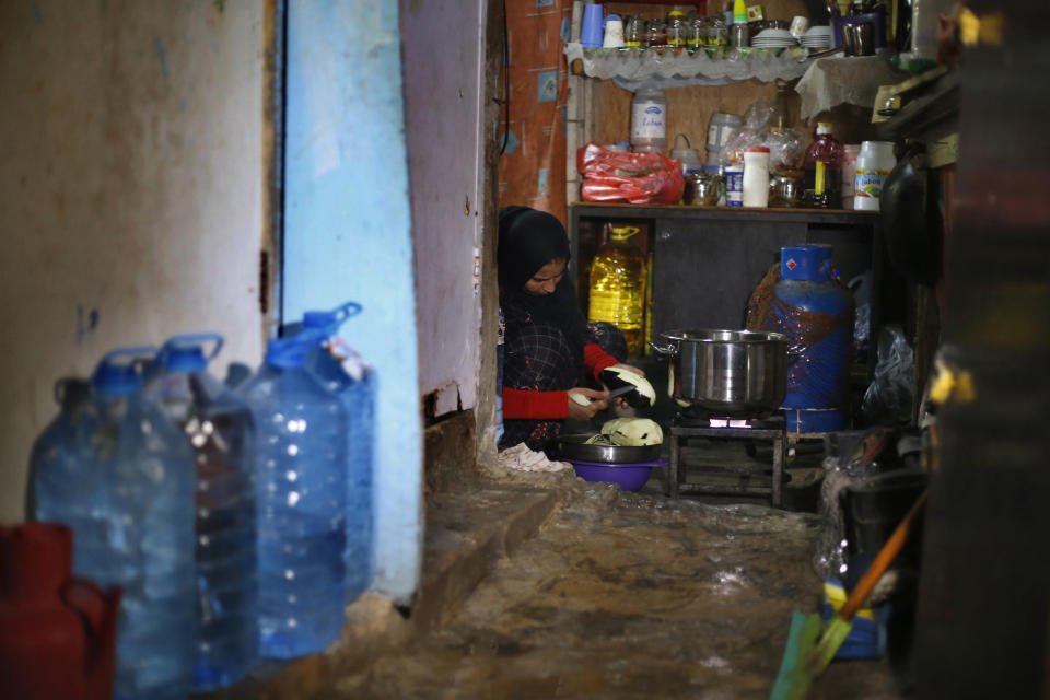 In this Tuesday, Dec. 18, 2018, photo, Syrian refugee Rozan Qarqour prepares lunch at her home in Ouzai refugee compound, in the southern port city of Sidon, Lebanon. A much touted Russian initiative to facilitate the return of Syrian refugees has fizzled out, with the return of only about 114,000 Syrians - out of more than 5 million in the region and Europe. In Lebanon, which hosts the highest ratio of refugees per capita, most of the estimated 1.2 million Syrians say the intend to stay put, citing economic concerns, ongoing fighting and destroyed homes. (AP Photo/Bilal Hussein)