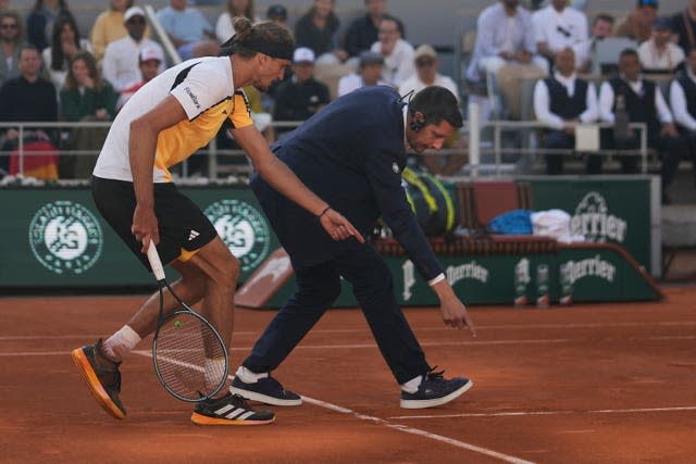 Alexander Zverev questions a decision with the umpire on court