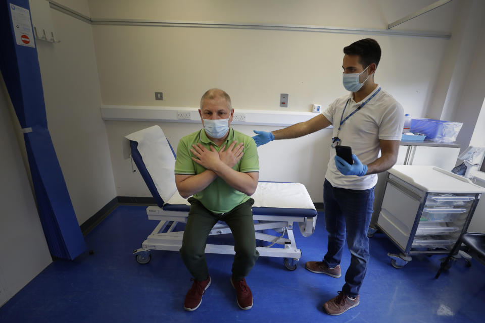 Long COVID patient Gary Miller, left, receives treatment from physiotherapist Joan Del Arco at the Long COVID Clinic at King George Hospital in Ilford, London, Tuesday, May 11, 2021. The clinic has been set up to help patients suffering months after they were infected with COVID-19. It's one of 83 "long COVID" clinics in England where medics and patients are grappling with the enduring effects of the virus. For taxi driver Miller, recovery is agonizingly slow. He says there are times "I feel like I'm taking one step forward, and then all of a sudden — bang — I'm ill again and I take two steps back." (AP Photo/Kirsty Wigglesworth)