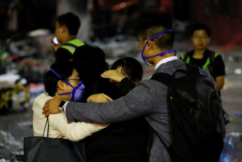 Anti-government demonstrators come out of the Hong Kong Polytechnic University (PolyU) to surrender during clashes with police, in Hong Kong