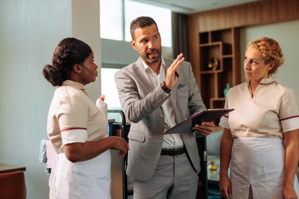 A man speaks to two women in uniform.