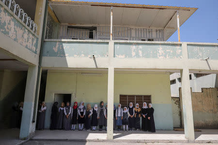 Pupils stand in from their classroom at an elementary school in eastern Mosul, Iraq, April 17, 2017. REUTERS/Marko Djurica