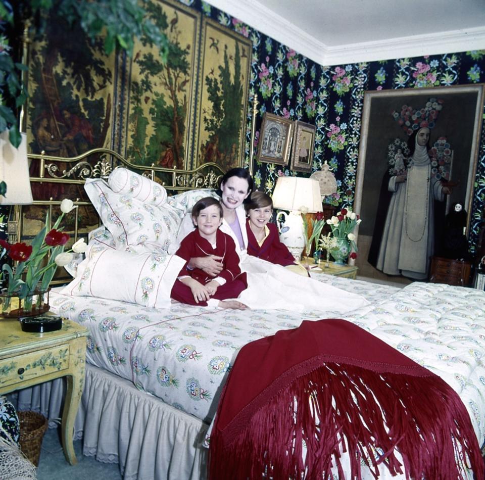 <h1 class="title">Gloria Vanderbilt sits on her bed with her two sons, Anderson and Carter.</h1><cite class="credit">Photographed by Horst P. Horst, <em>Vogue</em>, June 1975</cite>