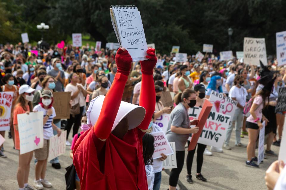 In this Oct. 2, 2021 file Cindy Gomez, of Austin, attends the Women's March ATX rally, at the Texas State Capitol in Austin, Texas. A federal judge has ordered Texas to suspend a new law that has banned most abortions in the state since September. The order Wednesday, Oct. 6, by U.S. District Judge Robert Pitman freezes for now the strict abortion law known as Senate Bill 8.