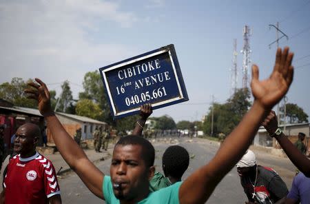 A protester holds a street sign during a protest against President Pierre Nkurunziza's decision to run for a third term in Bujumbura, Burundi, May 29, 2015. REUTERS/Goran Tomasevic
