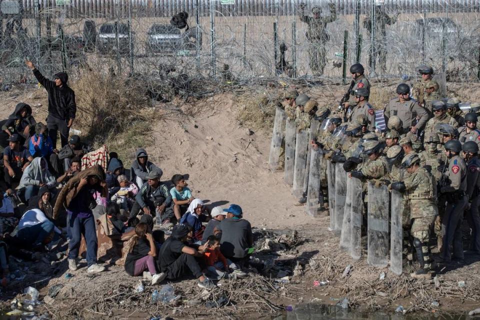 Texas National Guard and Texas State Troopers use anti-riot gear to prevent asylum seekers from entering further into U.S. territory after the migrants crossed the Rio Grande into El Paso, Texas from Ciudad Juarez, Mexico, on March 22.