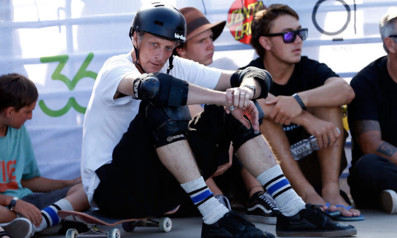A closeup of Tony Hawk resting on his skateboarding.