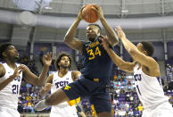 West Virginia forward Oscar Tshiebwe (34) pulls down a rebound as TCU defenders Kevin Samuel (21), PJ Fuller (4) and Desmond Bane (1) look on during the first half of an NCAA college basketball game, Saturday, Feb. 22, 2020 in Fort Worth, Texas. (AP Photo/Ron Jenkins)