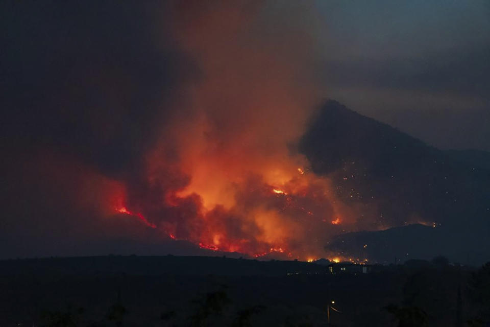 In this photo provided by Joseph Pacheco, a wildfire is seen burning in Globe, Ariz., on Monday, June 7, 2021. Firefighters in Arizona were fighting Tuesday to gain a foothold into a massive wildfire, one of two that has forced thousands of evacuations in rural towns and closed almost every major highway out of the area. (Joseph Pacheco via AP)