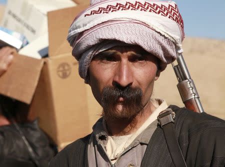 A man from the minority Yazidi sect stands guard at Mount Sinjar, in the town of Sinjar, December 21, 2014. REUTERS/Ari Jalal