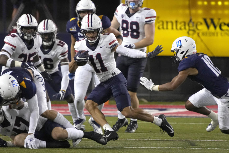 Arizona wide receiver Tayvian Cunningham (11) stiff arms Northern Arizona defensive back Trejan Apodaca (10) during the first half of an NCAA college football game, Saturday, Sept. 18, 2021, in Tucson, Ariz. (AP Photo/Rick Scuteri)