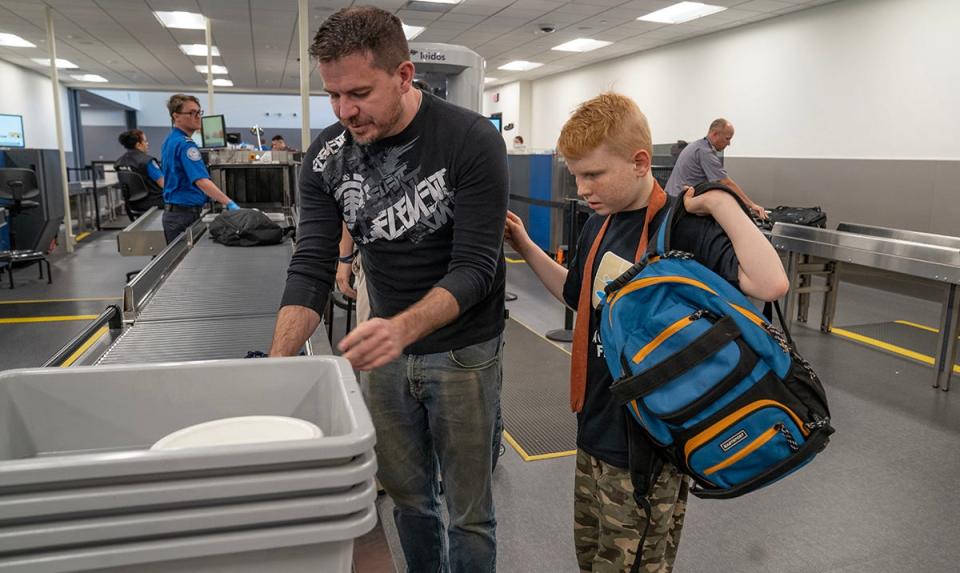 Bryan Nixon and his son Carson,10, of Eagle Mountain, Utah, gather their things after going through TSA at the Provo, Utah Airport. Breeze Airways hosted an exercise for people with autism, ages 3-20, to experience the process of airplane procedures to make future travel easier. The exercise took place at Provo Airport in Provo, Utah.