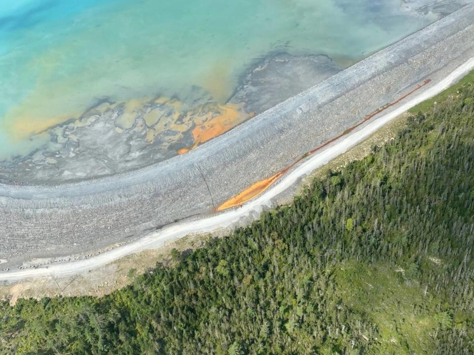 A photo of the tailings pond at the Moose River, N.S., gold mine shows discoloured material inside the pond and in a containment area outside the pond. (Contributed - image credit)