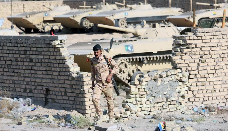 A member of Iraqi army forces guards at the entrance of Umm Qasr Port as protesters block the road during ongoing anti-government protests, south of Basra