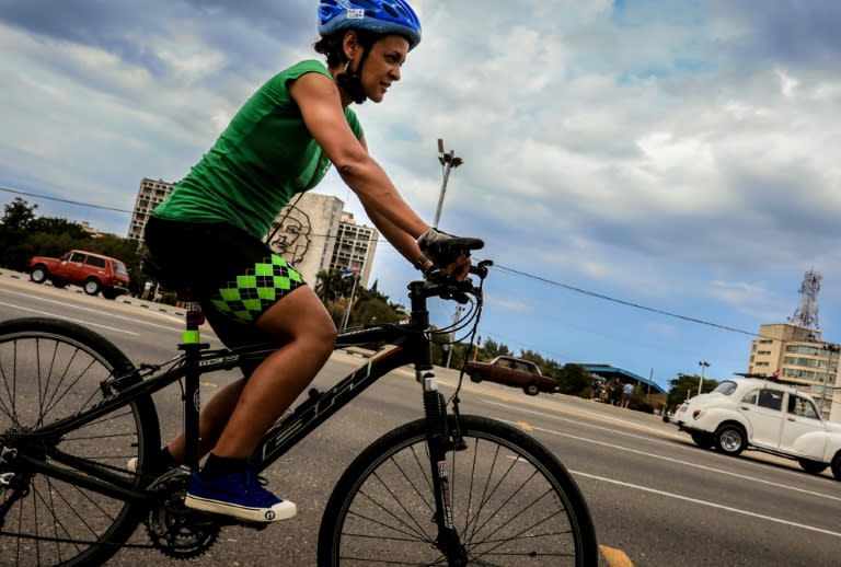 Naivis Diaz, the owner of the VeloCuba bicycle repair and rental agency, rides a bike past Revolution Square in Havana